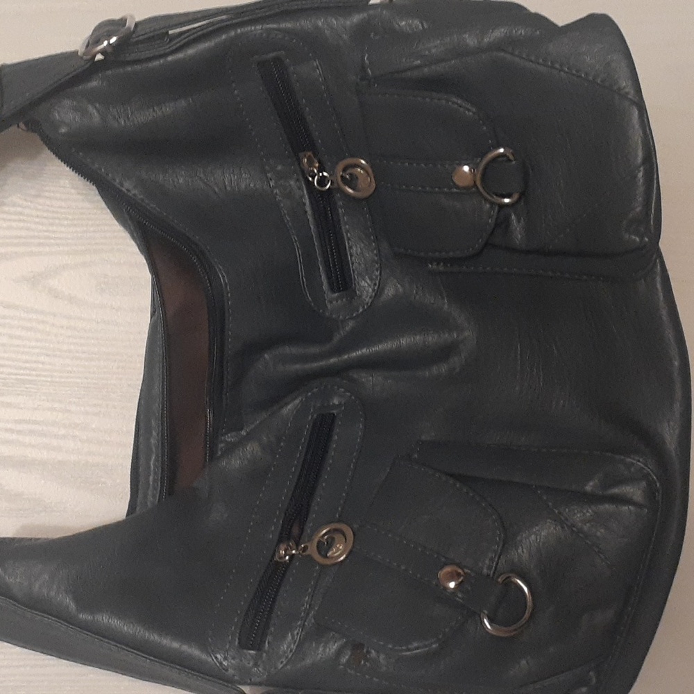 blue faux leather crossbody/backpack. Brand New, slight flaw, uneven pocket.